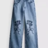 7-15 jaar | Jeans met wijde pijpen en geborduurde bloemenstrik