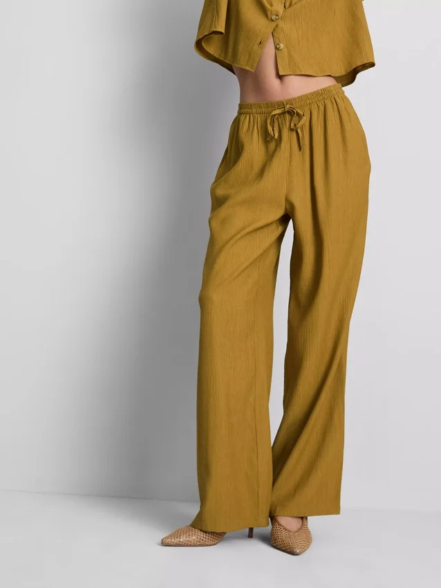 Broek met gekreukelde stof en wijde pijpen