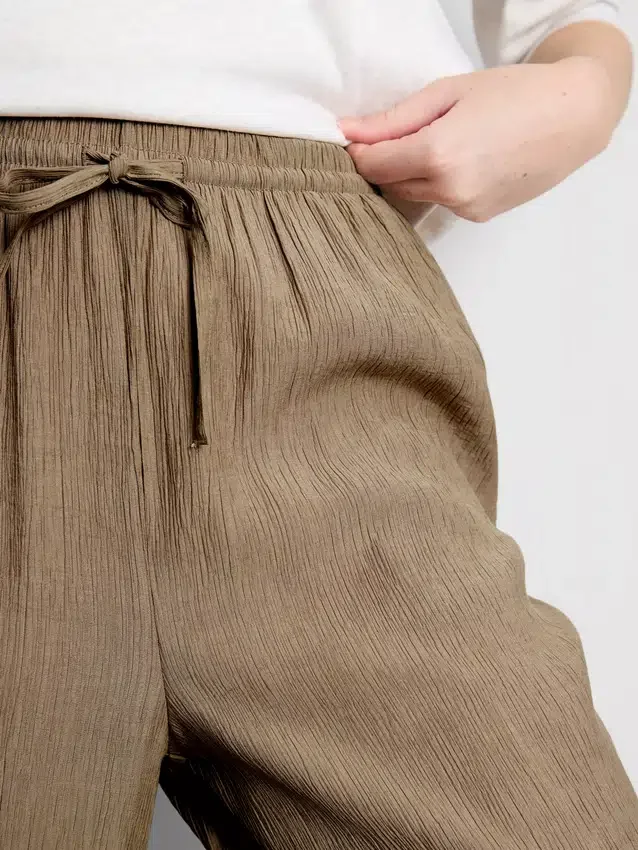 Broek met gekreukelde stof en wijde pijpen