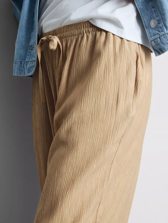 Broek met gekreukelde stof en wijde pijpen