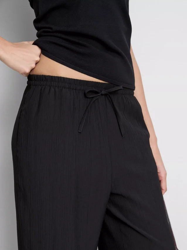 Broek met gekreukelde stof en wijde pijpen