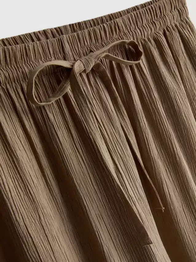 Broek met gekreukelde stof en wijde pijpen