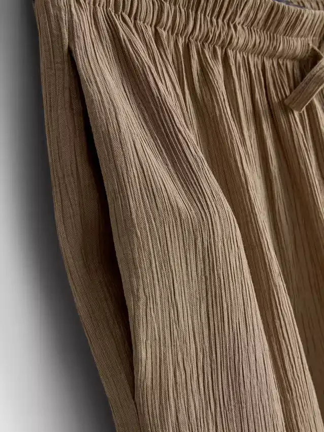 Broek met gekreukelde stof en wijde pijpen