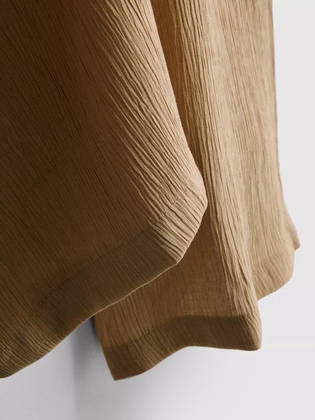 Broek met gekreukelde stof en wijde pijpen