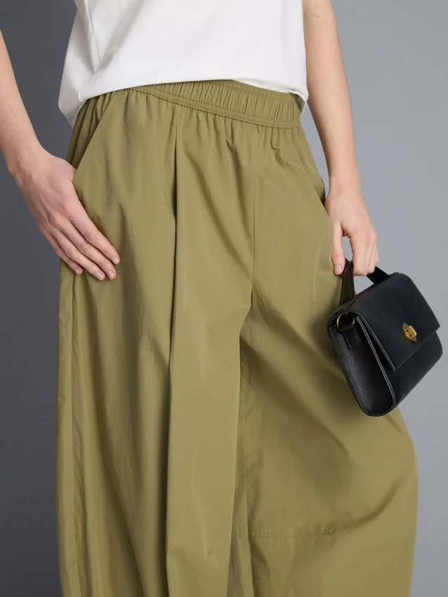 Broek met plooien en wijd uitlopende pijpen met papierachtige textuur