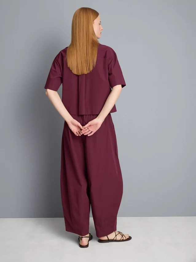 Broek met plooien en wijd uitlopende pijpen met papierachtige textuur