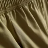 Broek met plooien en wijd uitlopende pijpen met papierachtige textuur
