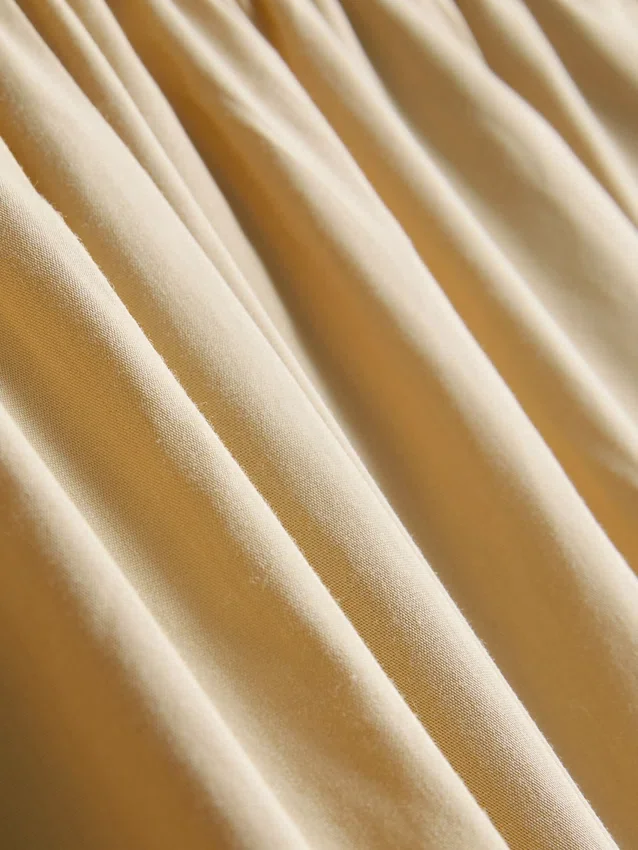 Broek met plooien en wijd uitlopende pijpen met papierachtige textuur
