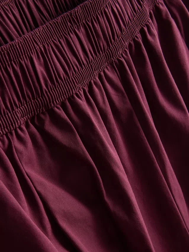 Broek met plooien en wijd uitlopende pijpen met papierachtige textuur