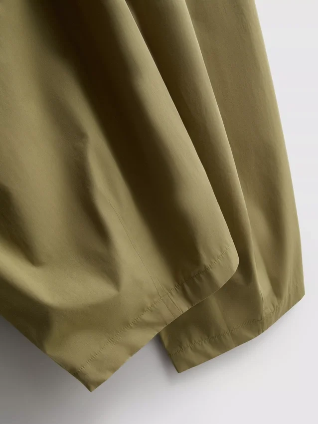 Broek met plooien en wijd uitlopende pijpen met papierachtige textuur