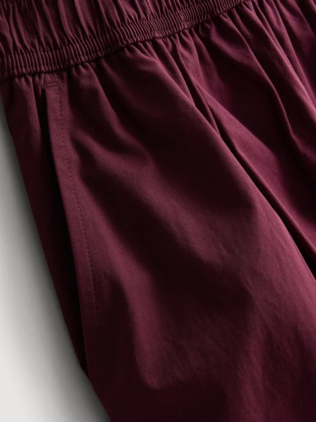 Broek met plooien en wijd uitlopende pijpen met papierachtige textuur