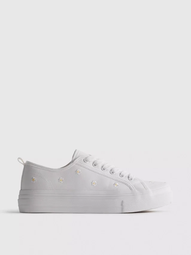 Sneakers met geborduurde madeliefjes
