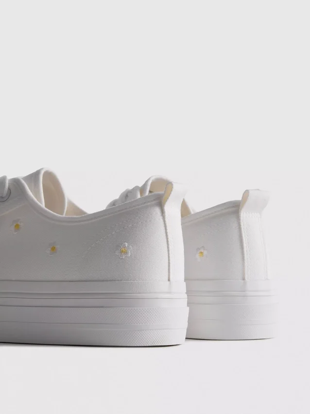 Sneakers met geborduurde madeliefjes