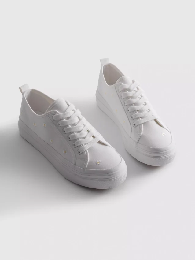 Sneakers met geborduurde madeliefjes