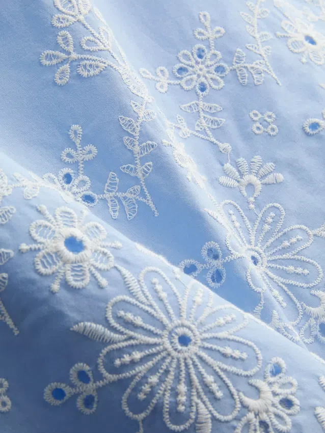 Top met broderie en strik aan de zijkant